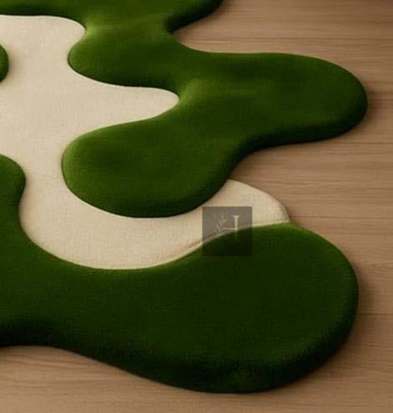 May include: A modern, abstract rug with a unique, organic shape. The rug features a contrasting color scheme with a deep green, plush texture and a creamy white, creating a visually appealing design. The rug's design adds a touch of contemporary style to any space.