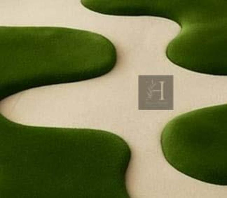 May include: A close-up of a rug with a unique design. The rug features a cream-colored background with large, organic shapes in a deep green color. The shapes are reminiscent of lily pads or flowing water, creating a modern and artistic look.