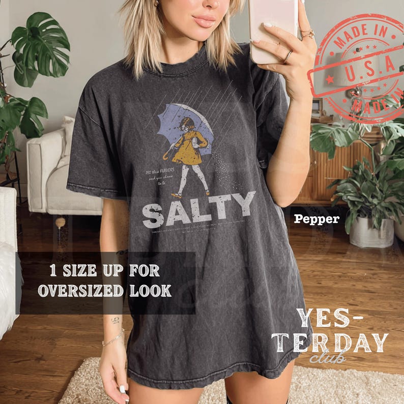Vintage 90s style "Salty Girl" typography graphic, coastal beach aesthetic with a distressed retro look, printed on a Comfort Colors garment-dyed tee, feminine summer streetwear.