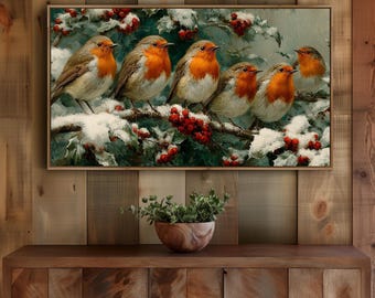 May include: A framed painting shows six robins on a snow-covered branch with red berries. The birds have orange breasts. The artwork is set against a backdrop of green foliage and a snowy background. The painting is displayed on a wooden surface.