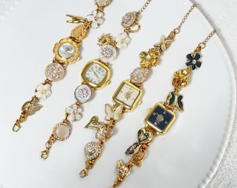 Pulseira de relógio artesanal - Joia de designer com botões florais e pingentes dourados, ideal para presentear um relógio de pulso pequeno.