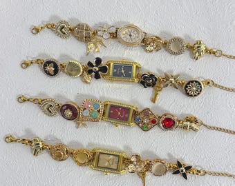 May include: Four gold-toned charm bracelets with various decorative elements. Each bracelet features a watch face and an assortment of charms, including hearts, flowers, and geometric shapes. The bracelets are displayed on a white surface.