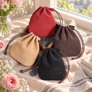 Puede incluir: Cuatro pequeñas bolsas con cordón en rojo, beige, marrón oscuro y negro, cada una con el texto en relieve Sugar To Night. Las bolsas están hechas de un material suave similar a la gamuza con cordones marrones a juego alrededor de una bandeja.