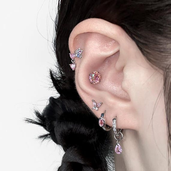 Pink butterfly titanium steel studs paired with dainty hoop earrings for a sparkly cartilage piercing.