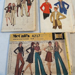 Puede incluir: Tres sobres de patrones de costura vintage que incluyen Butterick 6508, Butterick 6801 y McCall's 4217. Cada sobre presenta ilustraciones de varios estilos de ropa, talla 12, busto 34, y una cinta métrica amarilla a lo largo del patrón McCall's.
