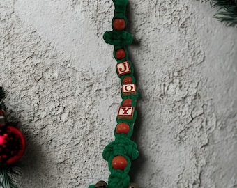 Colgante de puerta de macramé vintage de los años 70 con la palabra "JOY" • Decoración navideña bohemia • Cordón verde • Bloques de madera y cascabeles
