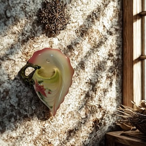 May include: A white ceramic mug with a black handle and the text "But First, Coffee" in a black, handwritten-style font. The mug is on a white surface.
