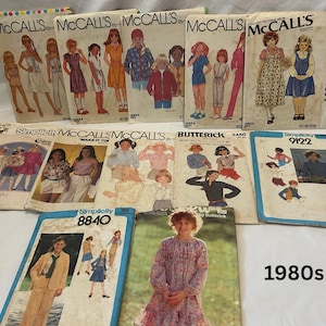Puede incluir: Una colección de patrones de costura vintage de la década de 1980, con ilustraciones de diseños de ropa para niños y adultos. Los patrones son de marcas como McCall's, Simplicity y Butterick. El texto "1980s" es visible.