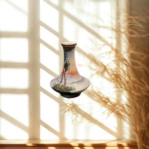 Könnte beinhalten: Eine dekorative Keramikvase mit breitem Fuß und schlankem Hals. Die Vase zeigt eine gemalte Landschaftsszene mit Sonnenuntergang, Bäumen und einem Segelboot. Die Farbpalette umfasst Blau-, Orange- und Grüntöne.