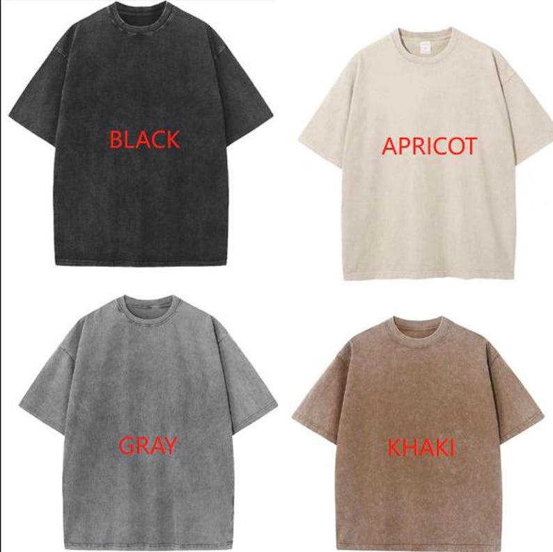 May include: Four short-sleeved t-shirts in black, apricot, gray, and khaki. Each shirt has a crew neck and the color name printed in red. The shirts have a slightly faded, vintage look.