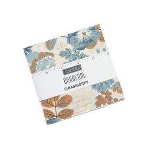 May include: A square stack of fabric squares featuring a floral pattern in shades of blue, tan, and cream. A white paper band wraps around the center, printed with the text Moda Fabrics Supplies, Decorum, and BasicGrey, showing a 9-inch ruler scale.