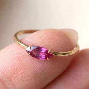 Könnte beinhalten: Ein Set aus drei Keramikbechern mit gesprenkelter, matter Oberfläche. Die Becher sind in Creme-, Hellgrau- und Dunkelgrautönen gehalten. Jeder Becher hat ein schlichtes, minimalistisches Design und einen abgerundeten Henkel.