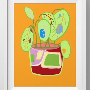 May include: Abstract art print of a potted plant with large green leaves and a red, pink, and green pot against an orange background. The artwork is framed in a white border.