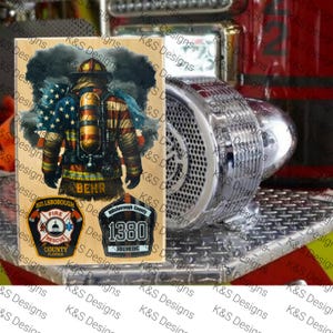 May include: A wooden plaque featuring a firefighter illustration with an American flag design. The image includes the name "BEHR" and patches for Hillsborough Fire Rescue and Firemedic 1380. The background shows a fire engine.