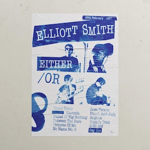 May include: A blue and white concert poster for Elliott Smith's "Either/Or" album, featuring images of the artist and song titles. The poster includes the date "28th February 1997" and a list of songs such as "Speed Trials" and "Angeles".