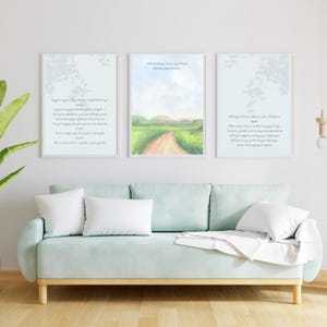 Puede incluir: Tres impresiones artísticas enmarcadas sobre un sofá verde claro. Las impresiones presentan texto y pinturas de paisajes en acuarela. El sofá tiene cojines blancos y una manta blanca. Una planta verde es visible a la izquierda.