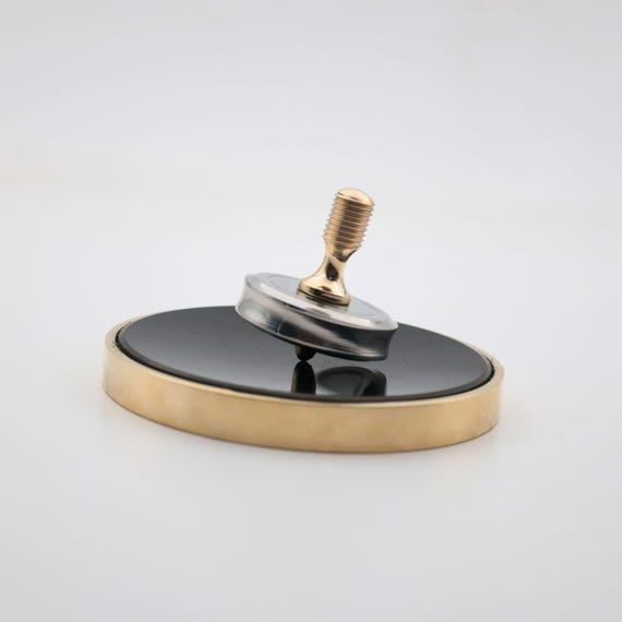 A solid machined-brass spinning top with a verified 4.5-minute spin time — the kind of satisfying desk object that makes everyone in the office stop and stare.