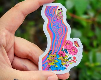 May include: A colorful sticker with a psychedelic design. It features a flowing river of orange, pink, and blue, with a frog playing a guitar and a meditating figure. Pink flowers and butterflies are also present.