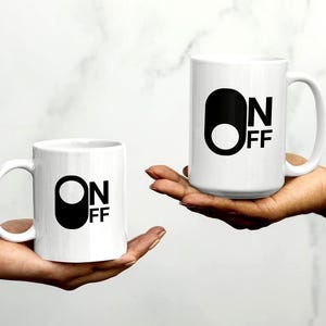 Eine weiße Kaffee- oder Teetasse aus Keramik mit lustigem Design für einen guten Start in den Tag, perfekt fürs Büro. Ein Geschenk für Kollegen.