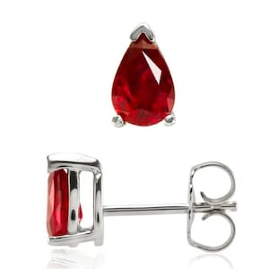 Könnte beinhalten: Ein Paar Ohrstecker mit tropfenförmigen, leuchtend roten Edelsteinen, gefasst in silberfarbenem Metall. Die Ohrringe haben ein klassisches Design mit Stecker und Butterfly-Verschluss, geeignet für Alltag und besondere Anlässe.