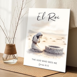 May include: A framed art print featuring a desert scene with a person kneeling near a well. The text "El Roi" is at the top, with "THE GOD WHO SEES ME Genesis 16:13" below the image. A glass vase with branches is on the left.