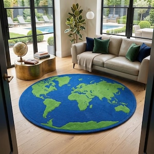 May include: A circular area rug featuring a vibrant blue ocean background and bright green landmasses depicting a world map. The rug has a soft, textured pile and is positioned on a light-colored wooden floor in a living space.