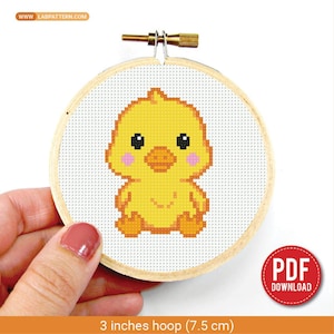 Può includere: Un telaio da ricamo a punto croce con un disegno di pulcino giallo, guance rosa e occhi neri. Il telaio misura 7,5 cm di diametro e ha una cornice in legno. L'immagine include il testo "PDF DOWNLOAD".