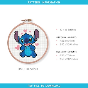 May include: A cross-stitch pattern featuring the character Stitch from Lilo & Stitch, in a wooden embroidery hoop. The design includes Stitch surrounded by pink hearts. The pattern details are listed, including the size in inches and centimeters.