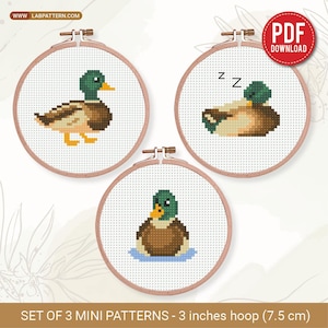 May include: Three cross-stitch patterns of ducks in embroidery hoops. Each duck has a different pose: standing, sleeping, and swimming. The hoops are 3 inches (7.5 cm) in diameter. The text "PDF DOWNLOAD" is in a red circle.