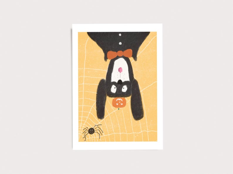 Peut inclure: Une impression d'art rectangulaire repr&eacute;sentant un chien noir avec un poitrail blanc et un n&oelig;ud papillon orange suspendu &agrave; l'envers sur un fond jaune avec un motif de toile d'araign&eacute;e blanche. Une petite araign&eacute;e noire et une citrouille sont visibles.