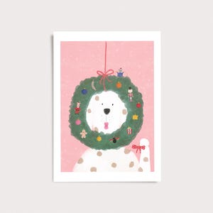 Peut inclure: Un chien blanc &agrave; taches brunes portant une couronne de No&euml;l verte autour du cou sur un fond rose. La couronne est d&eacute;cor&eacute;e de petits ornements, dont un casse-noisette, un bonhomme en pain d'&eacute;pices et des cadeaux, nou&eacute;e par un ruban rouge.