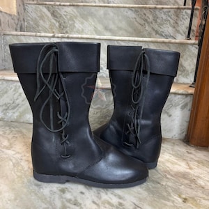 Detailed view of leather sole and quality construction of tall medieval boots.