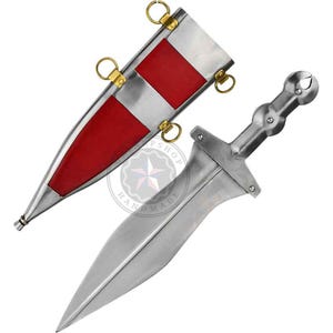 May include: A silver-colored dagger with a pointed blade and a handle with a rounded end. The dagger is next to its sheath, which is silver with red and white accents and gold-colored rings.