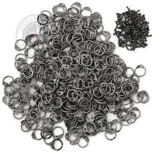 May include: A large pile of small, dark gray metal rings with a circular design and a small tab. A separate pile of small, dark gray screws is also present. The items are likely hardware components.