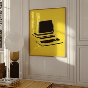 Puede incluir: Una impresión de arte mural rectangular que presenta una ilustración negra de alto contraste de una computadora de escritorio vintage con monitor y teclado, centrada sobre un fondo amarillo vibrante y sólido, dentro de un marco de madera claro.