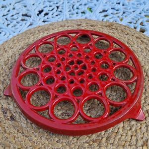 Vintage ornate red cast iron pan kettle trivet round enamel hot plate stand retro French kitchen decor farmhouse geometric design