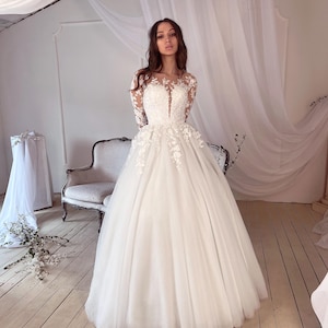 Delicate wedding dress. Adorned with floral lace.