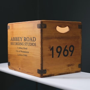 May include: A wooden crate featuring the text "ABBEY ROAD RECORDING STUDIOS" and the year "1969". The crate has metal corner brackets and a handle. The text includes the address "3 Abbey Road, City of Westminster, London NW8".