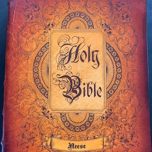 May include: A brown leather-bound Holy Bible with ornate gold detailing and the name "Neese" embossed on a ribbon banner.