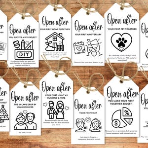 May include: A collection of white gift tags with black text and illustrations, tied with twine. Each tag reads "Open after" followed by a special occasion, such as a first home, anniversary, or baby. The tags are arranged on a wooden surface.