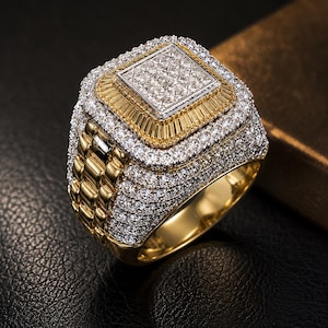 May include: A gold ring with a square, diamond-set centre. The ring has multiple layers of diamonds and gold detailing, with a textured band. The ring is set against a dark background.