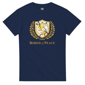 May include: Navy blue t-shirt with a gold and white graphic. The graphic features a shield design with a cracked globe, surrounded by a gold laurel wreath. The text "BORED of PEACE" is below the graphic.
