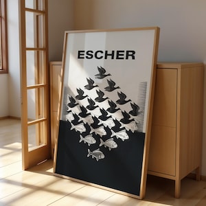 Könnte beinhalten: Ein rechteckiger gerahmter Kunstdruck mit dem Text ESCHER am oberen Rand. Das Kunstwerk zeigt ein tesselliertes Muster aus schwarzen Vögeln, die in weiße Fische übergehen, vor einem geteilten weiß-schwarzen Hintergrund mit geometrischem Design.