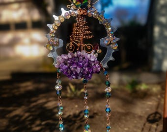 Atrapasueños de paseo en bicicleta bajo el sol, hecho con engranajes de bicicleta reciclados.