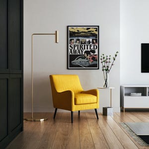 May include: A yellow armchair with black legs sits in a modern living room. A framed "Spirited Away" poster hangs on the wall. A gold floor lamp and a small side table with a vase of flowers complete the scene.