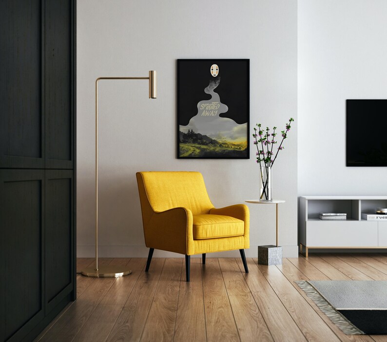 K&ouml;nnte beinhalten: Ein modernes Wohnzimmer mit einem gelben Sessel, einer goldenen Stehlampe und einem gerahmten Poster. Das Poster zeigt eine Landschaft mit dem Text "Spirited Away". Ein kleiner Beistelltisch h&auml;lt eine Vase mit Blumen. Der Raum hat Holzb&ouml;den.