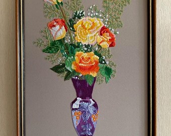 Op de afbeelding: Geborduurd kunstwerk van een bloemstuk in een paarse vaas. Het boeket heeft gele, oranje en rode rozen met groene bladeren. De vaas heeft een gedetailleerd ontwerp en staat op een grijze achtergrond, omlijst in een bruine houten lijst.