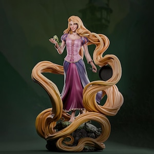 Könnte beinhalten: Eine Figur mit langem blondem Haar in einem rosa-violetten Kleid, die ein kleines grünes Chamäleon in der einen und eine schwarze Bratpfanne in der anderen Hand hält. Das Haar umfließt die Figur, die auf einem strukturierten Sockel steht.