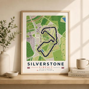 Könnte beinhalten: Ein gerahmter Kunstdruck mit einer detaillierten Karte des Silverstone Circuit im Vereinigten Königreich. Die Grafik zeigt den Streckenverlauf in Dunkelblau vor einer grünen und beigen Landschaft mit dem Text Silverstone Circuit.