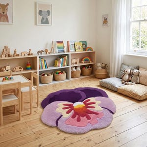 May include: A large, flower-shaped rug in a child's room. The rug is primarily purple with pink, yellow, and red accents. The room also features wooden shelves with toys, books, and baskets, along with a small table and chairs.